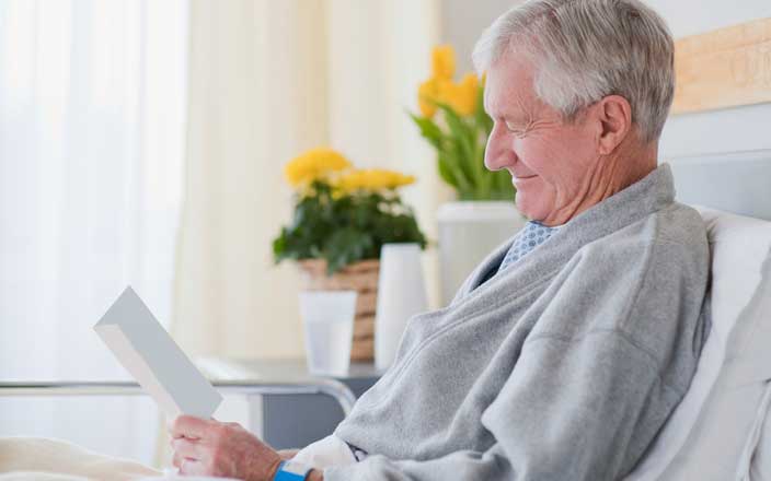 Smiling patient reading a get well soon note in a hospital