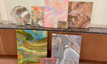 Surtido de piezas de arte sobre lienzo apoyado contra una pared
