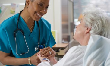 Nurse holding a patient's hand