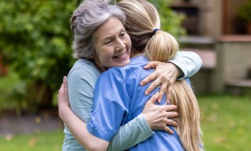 An older woman and younger woman hugging each other