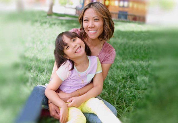 Mother and daughter sitting together in park setting